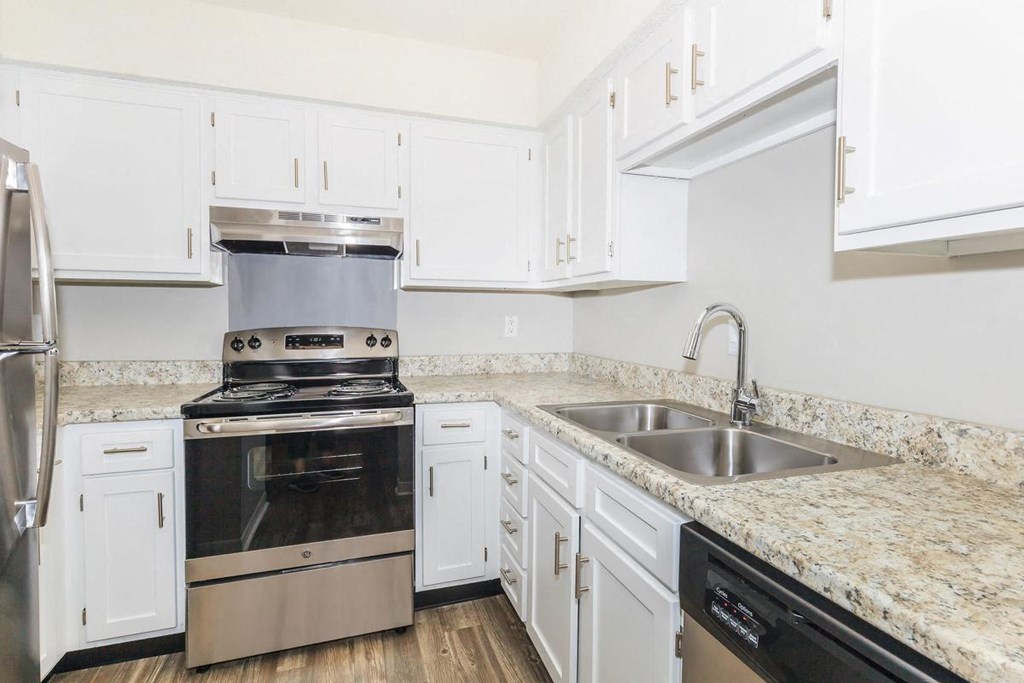 a kitchen with white cabinets and stainless steel appliances