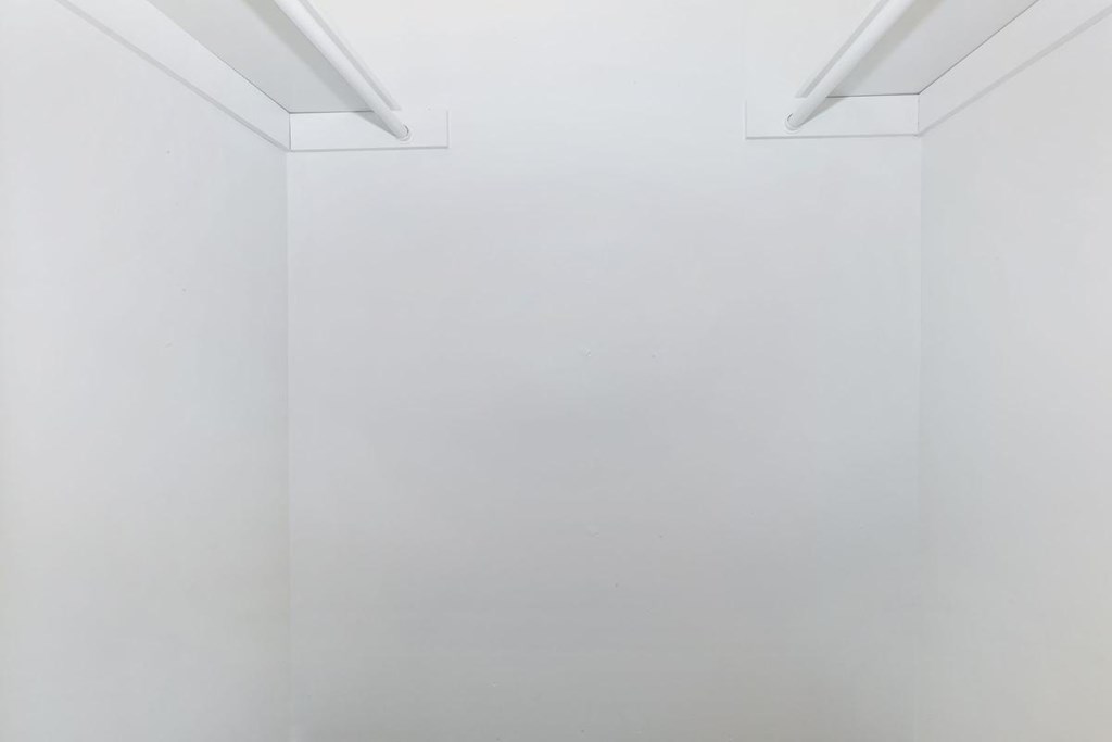 an empty room with white walls and a white ceiling and a window
