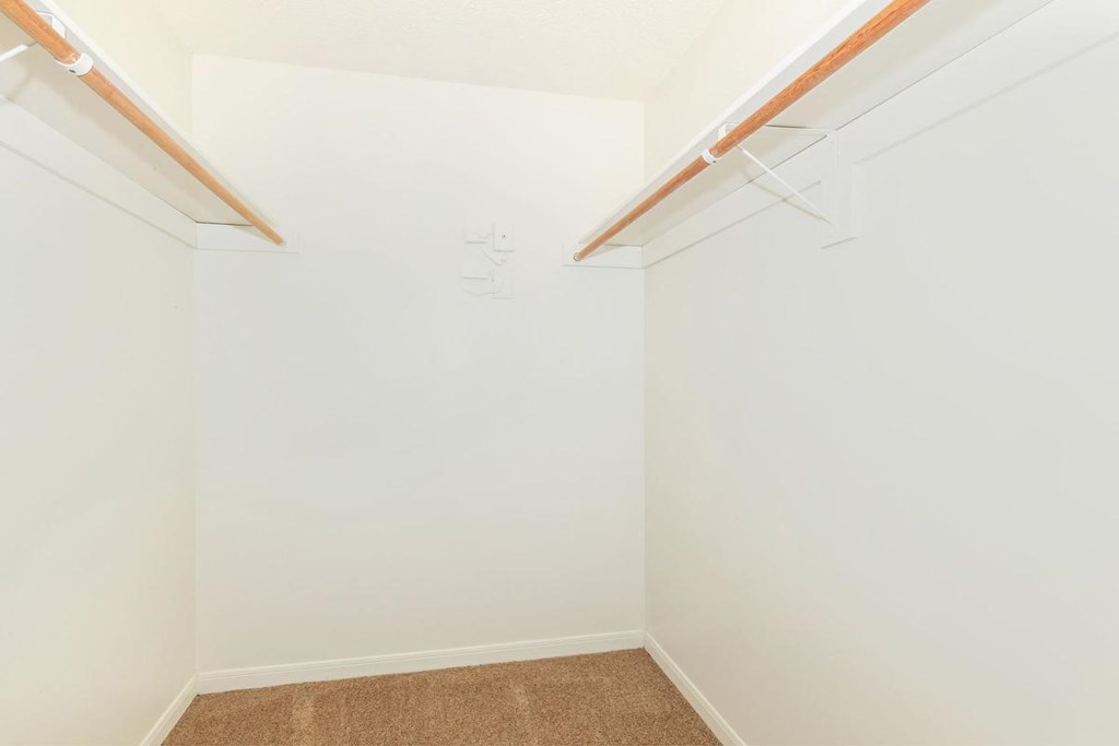 an empty room with white walls and a closet with a hanger