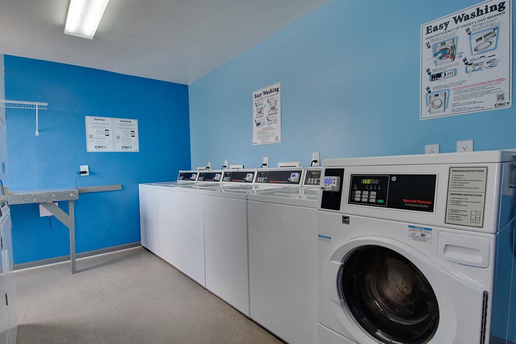 a row of washers and dryers in a laundry room