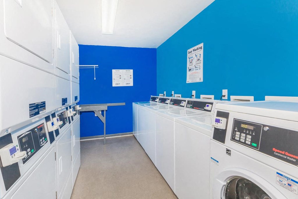 a laundry room with washes and dryers and a blue wall