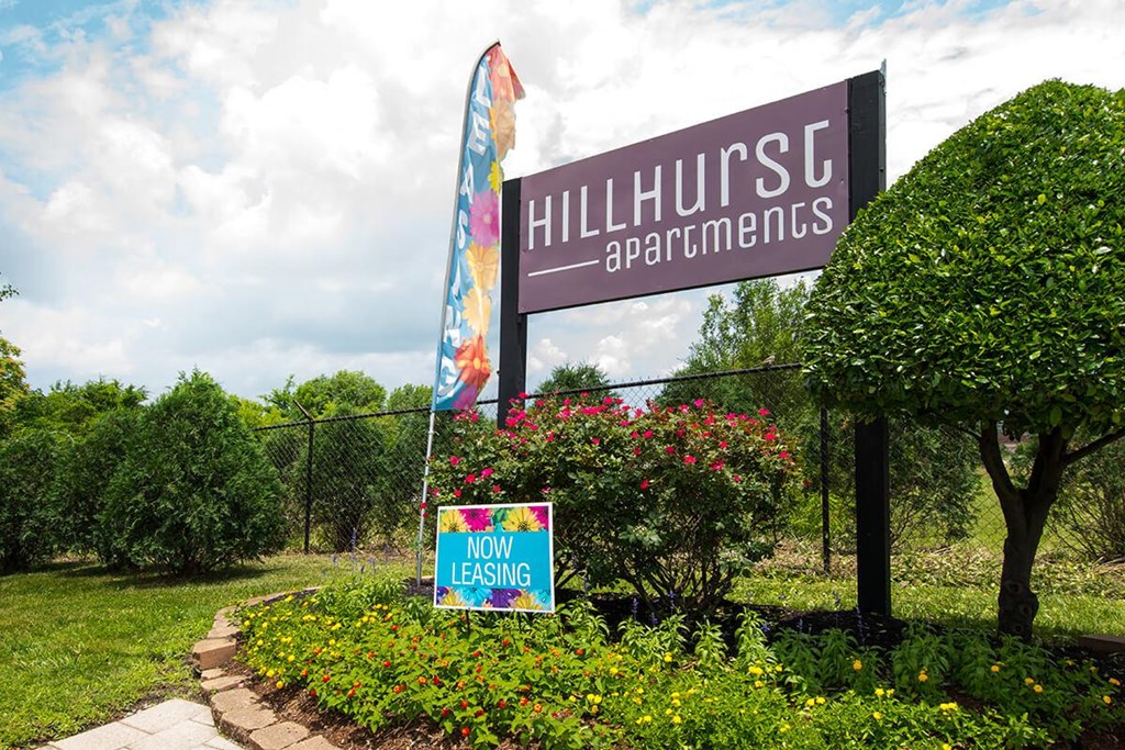a sign apartments in front of a fence