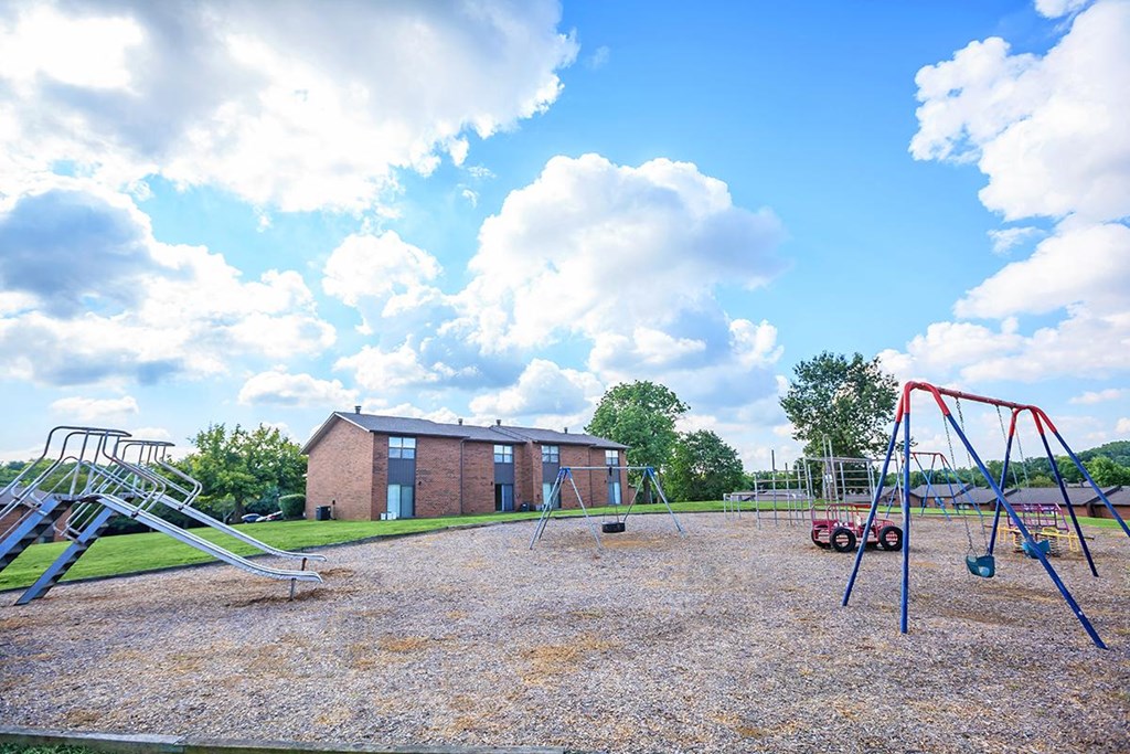 an empty playground in front of a brick building