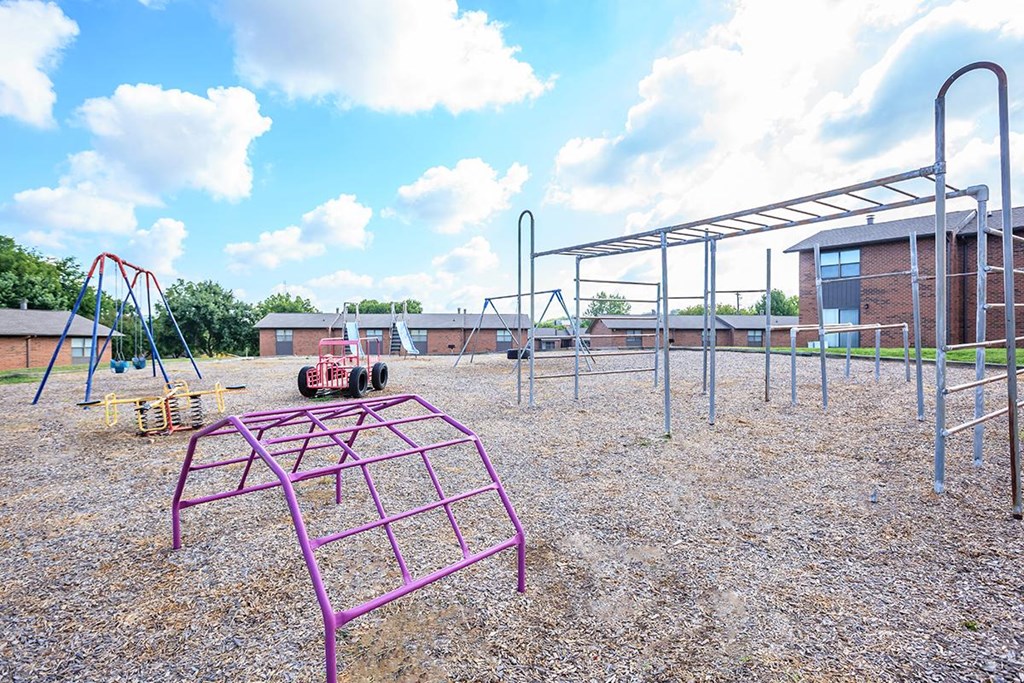 an empty playground at a school with a swing set