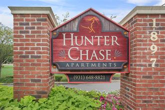 a sign for hunter chase apartments on a brick wall