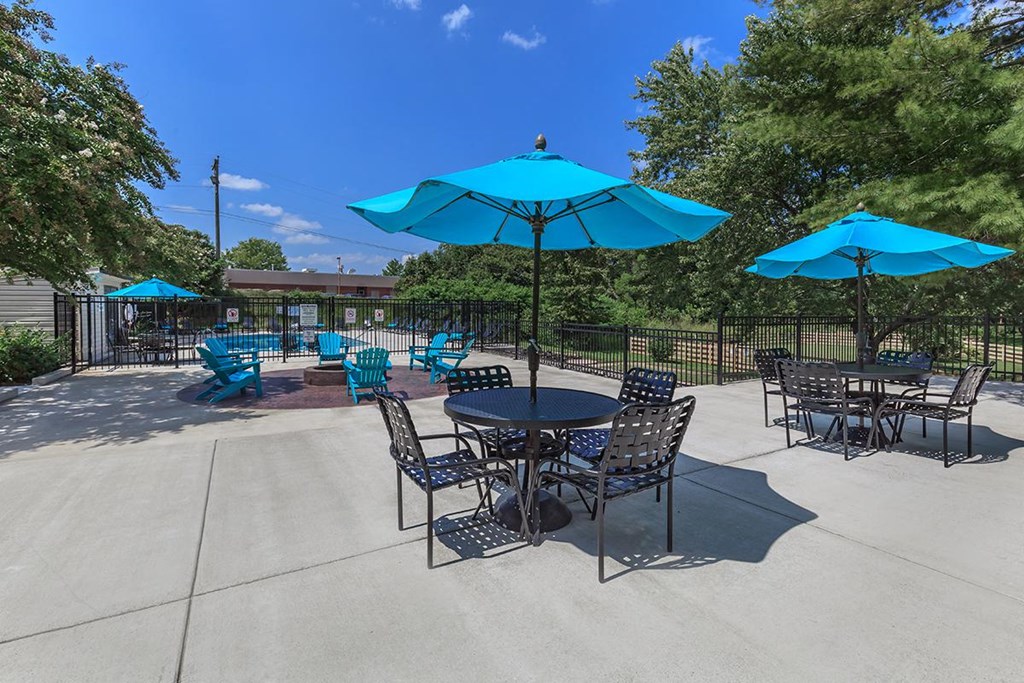 a patio with blue umbrellas and chairs and tables