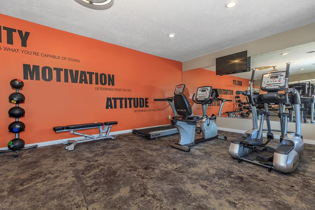 a gym with machines and a tv