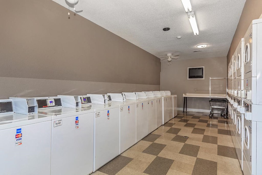 the laundry room is full of washes and dryers and a chair in front