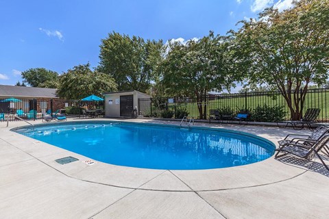 a resort style swimming pool with chairs around it