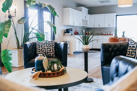A living room with a black leather chair and a white coffee table.
