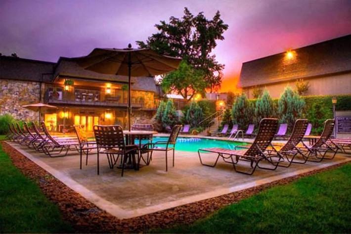 a backyard with a pool and chairs and an umbrella