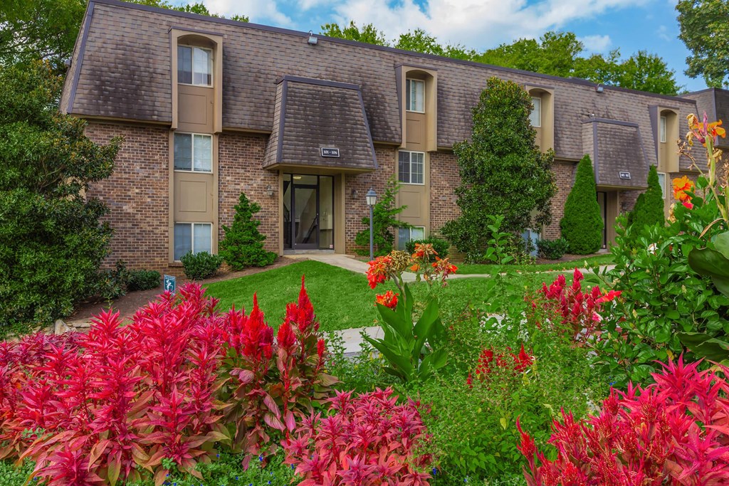 a garden in front of an apartment building with flowers