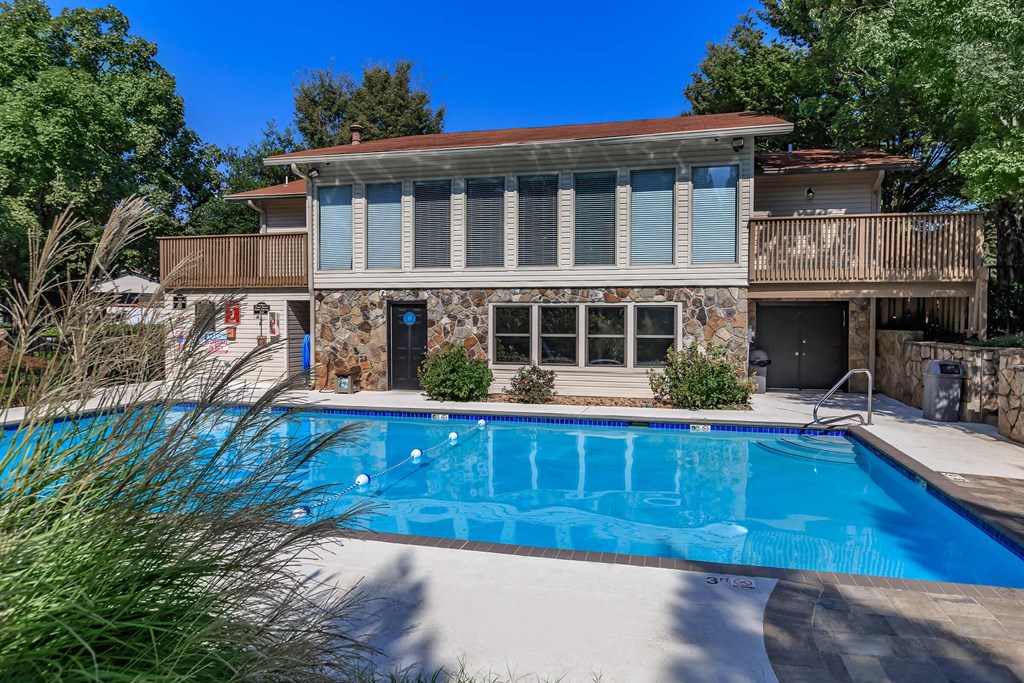 a swimming pool in front of a house with a pool