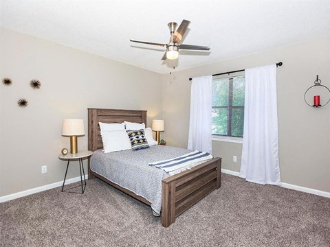 a bedroom with a bed and a ceiling fan