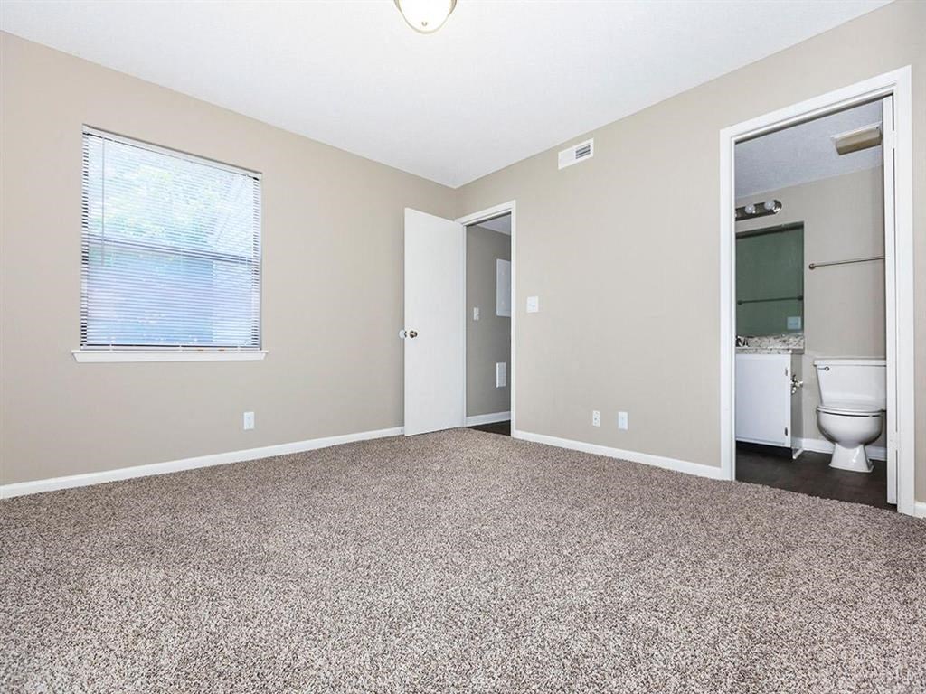 an empty room with a toilet and a window