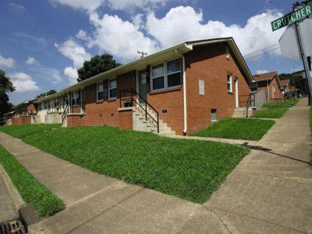 a row of brick apartment buildings on the side of a sidewalk