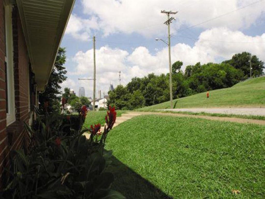 a view of the side of a house and a field of grass
