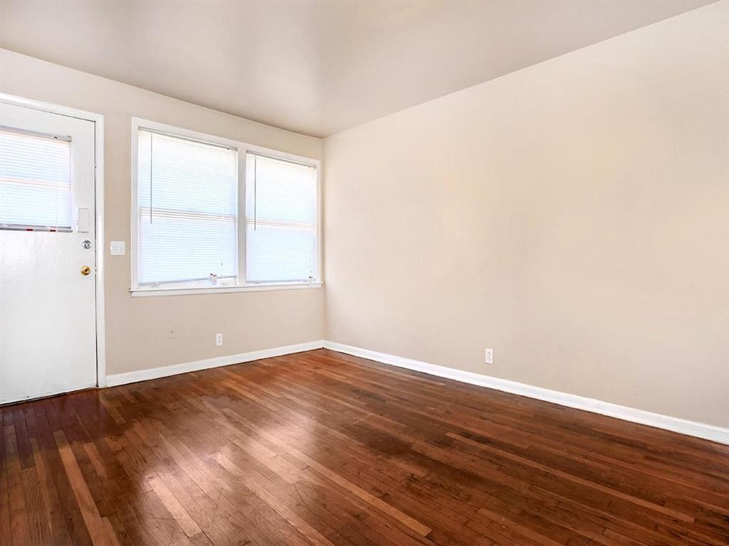 an empty room with a hard wood floor and a window