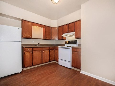 a kitchen with white appliances and wooden cabinets