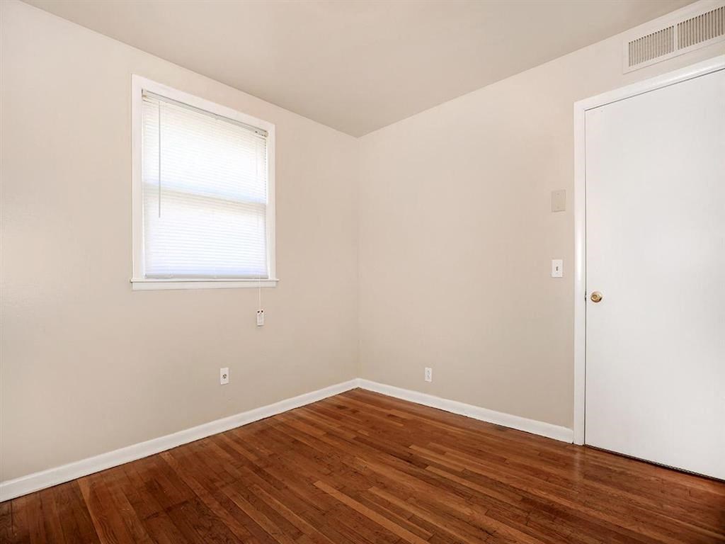 a room with a wooden floor and a window and a door