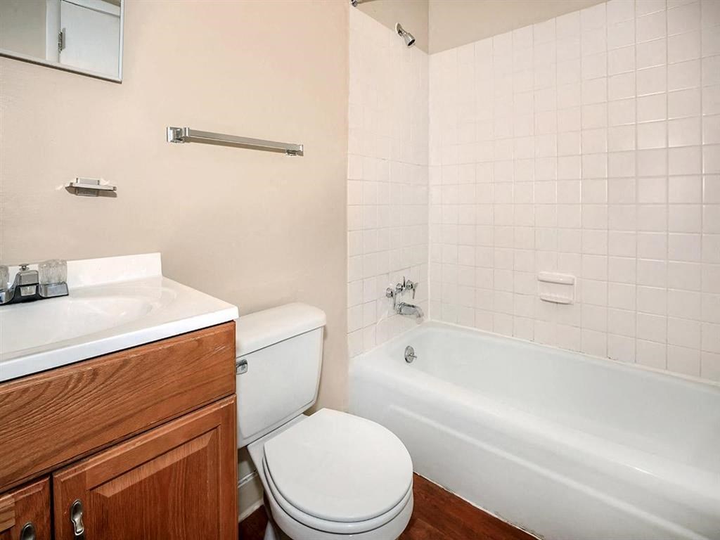 a bathroom with a toilet and a tub and a sink