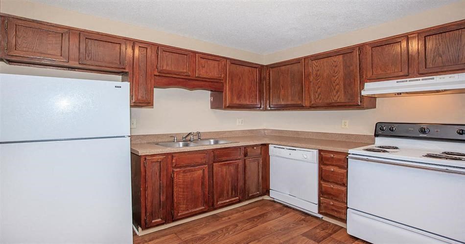 a kitchen with white appliances and wooden cabinets