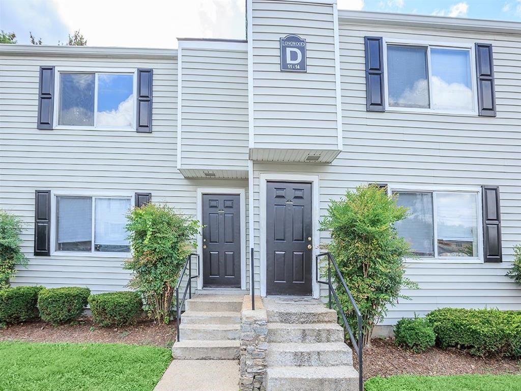 the front of a white house with two black doors