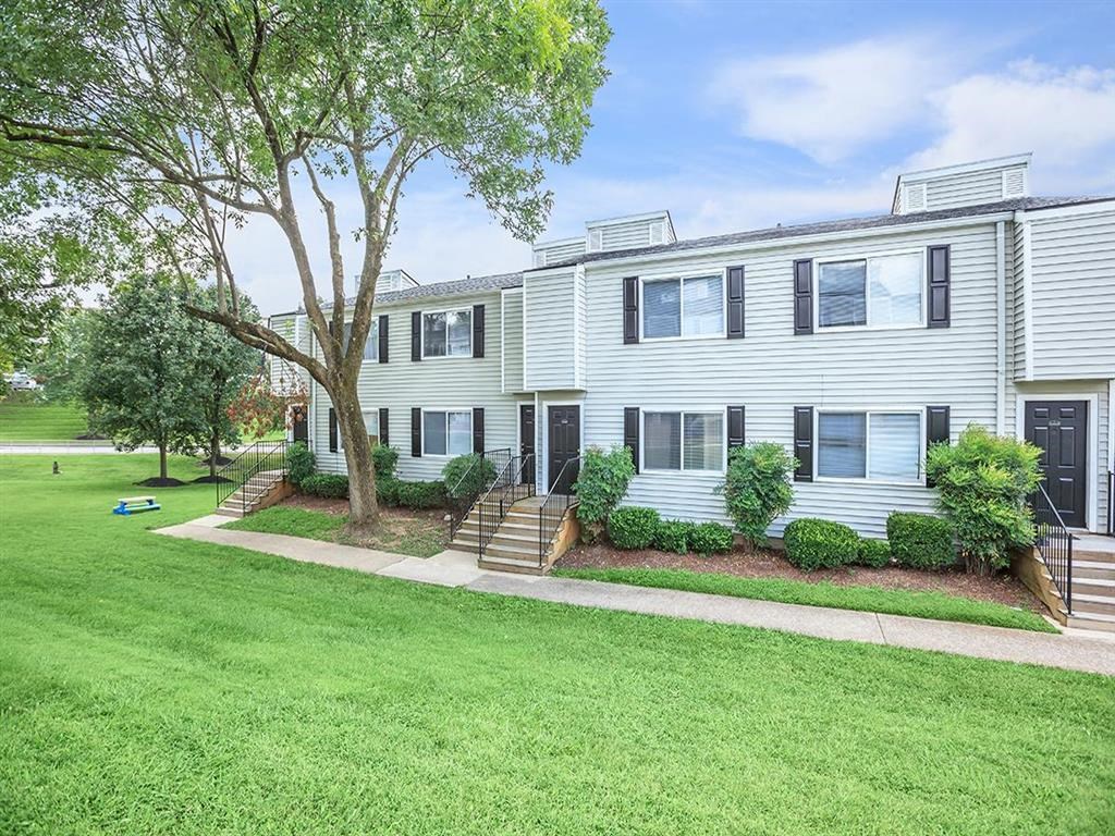 a white house with a lawn and trees in front of it