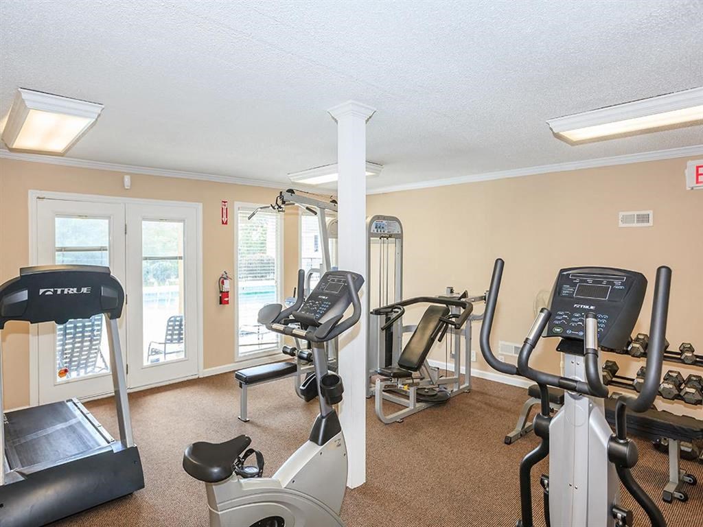 a gym with a lot of exercise equipment and windows