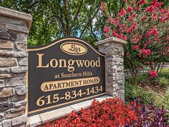 a sign for longwood at southern hills apartment homes with red flowers