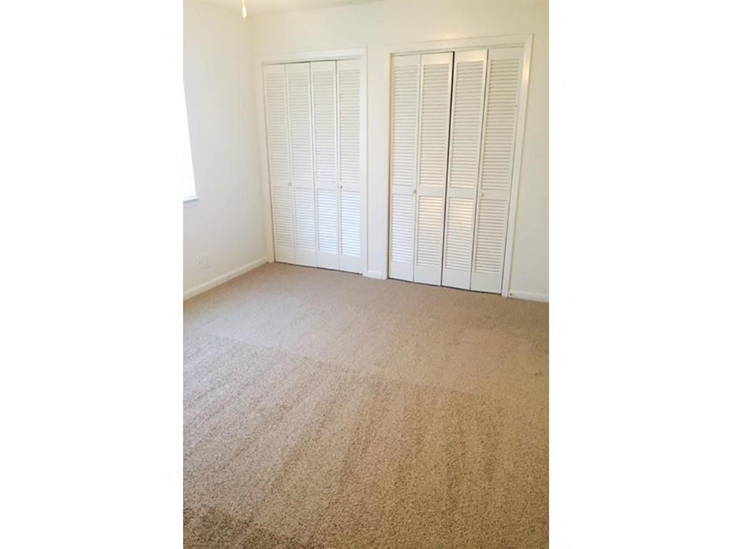 an empty living room with three closet doors