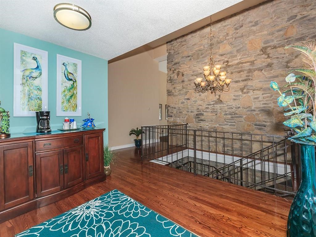 a living room with a stone wall and a chandelier