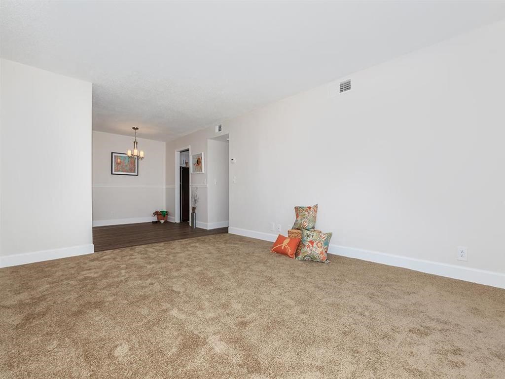 a living room with a couch and a chair on the carpet