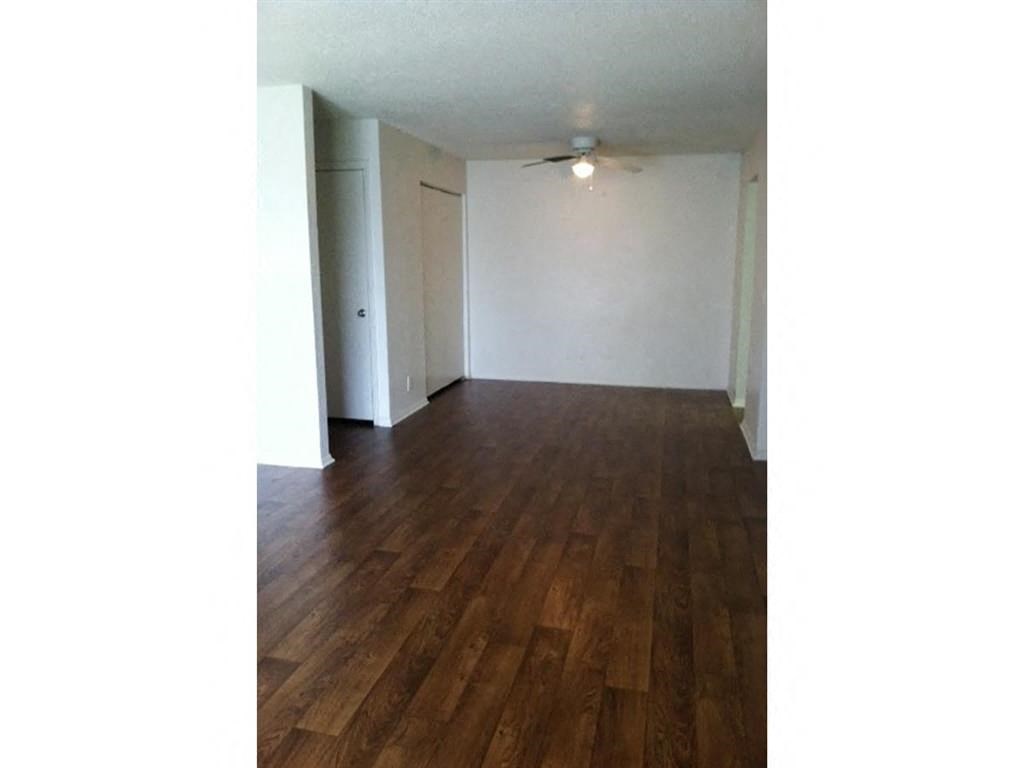 an empty living room with white walls and wood floors