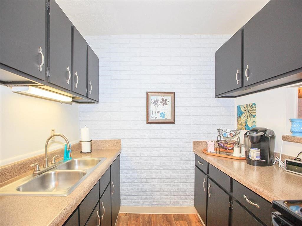 a kitchen with a sink and counters and black cabinets