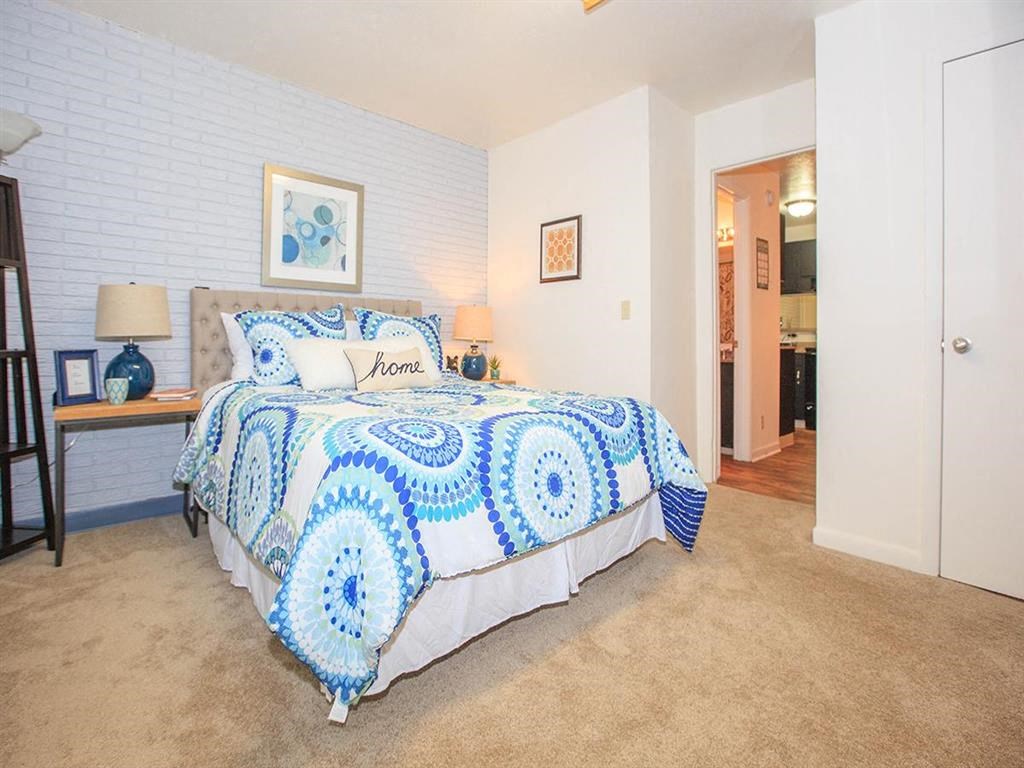 a bedroom with a bed and a blue and white comforter