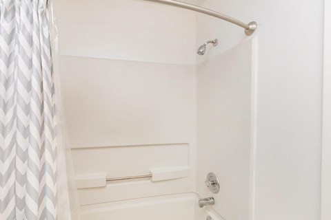 a white bathroom with a shower and a curtain