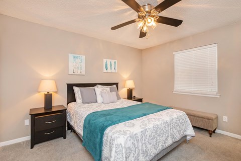 a bedroom with a large bed and a ceiling fan