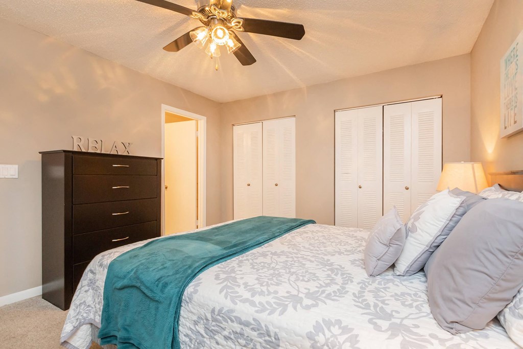 a bedroom with a large bed and a ceiling fan