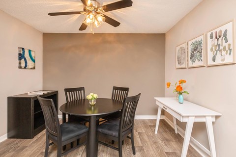 a dining room with a table and chairs and a ceiling fan