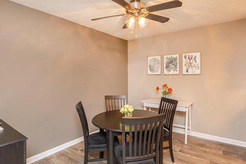 a dining room with a table and chairs and a ceiling fan