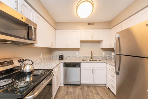 a kitchen with stainless steel appliances and white cabinets