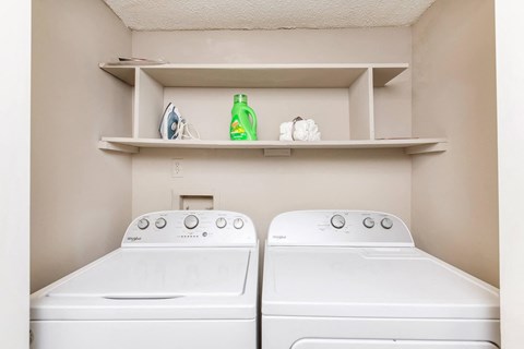 a washer and dryer in a laundry room with shelves