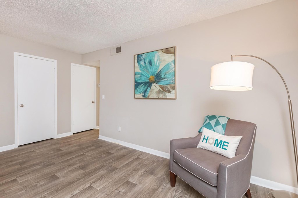 a living room with a chair and a lamp