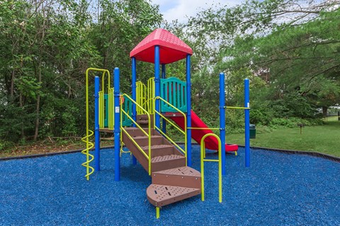 a colorful playground with a slide in a park