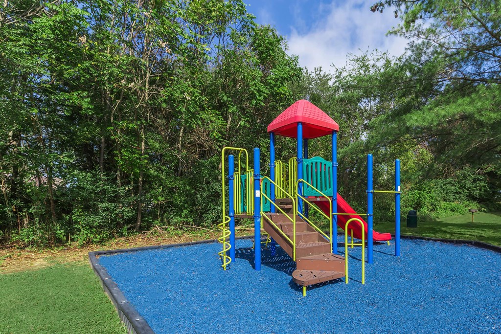 a colorful playground with a slide and other toys in a park