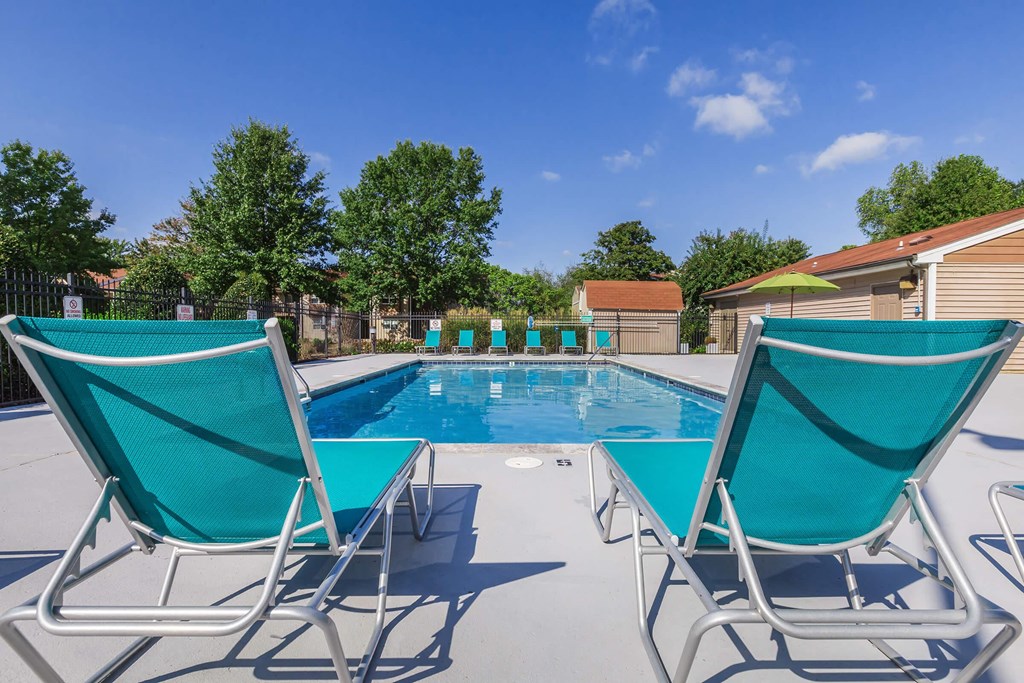 a swimming pool with lounge chairs and chairs around it