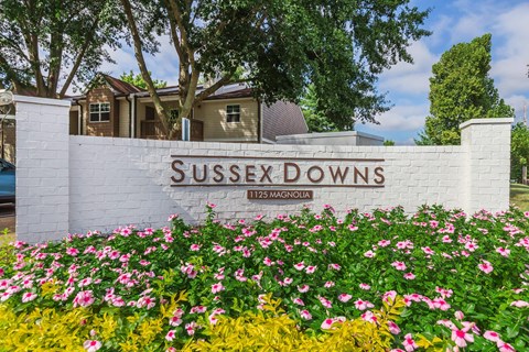 a sign downs in front of a house with flowers