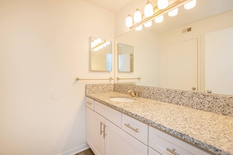 a bathroom with granite counter tops and a sink