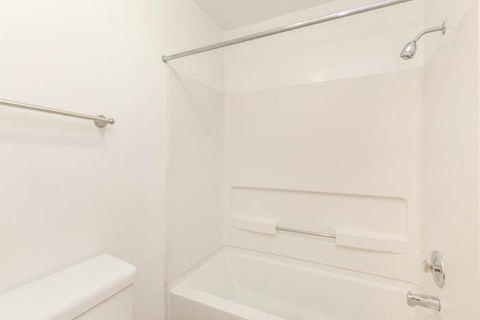 a white bathroom with a shower and a sink